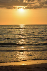 Obraz premium portrait of sunset in the ocean, sun reflection in the water.