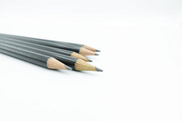 Close up of black sharpen pencils lay in a group isolated on white background with copy space.