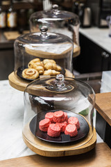 Freshly baked pile of pink color Scones inside glass dome lid. Eat with tea or coffee. Good bakes pastry.