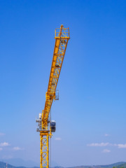 Yellow construction crane on bule sky background