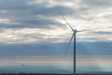 windmill generator on the background of the sky with clouds at dawn