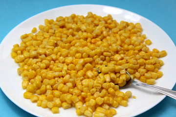 Canned corn with a spoon in a plate