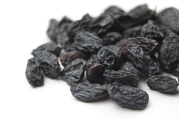 small pile of blue raisins on a white background