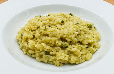Risotto with asparagus on wooden table. Italian food close-up