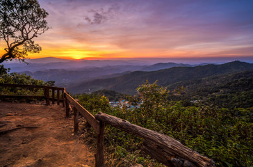 Mountain valley during sunset and village below. Beautiful landscape with forested hills