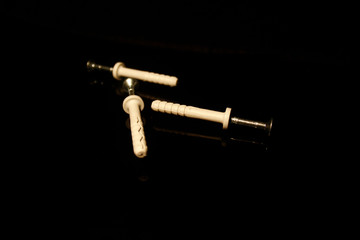 Three wall dowel pin with screw isolated on black with reflections