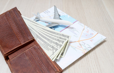 US dollar notes and travel maps