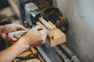 A man carves a tree. The carpenter works in a studio. An engineer provides a tree shape