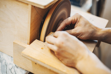 A man carves a tree. The carpenter works in a studio. An engineer provides a tree shape