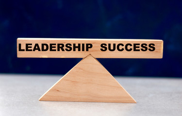 concept of word balance leadership and success on wooden scales