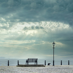 Fototapeta na wymiar Lonely empty bench seat coastal sea storm but peaceful quiet mindfulness scene view