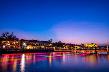 Fototapeta na wymiar Nightscape at Hoi An old town with passenger boat light trails