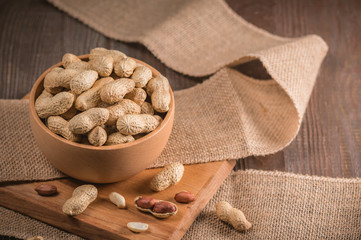 Peanuts in shells on wood background