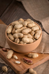 Peanuts in shells on wood background