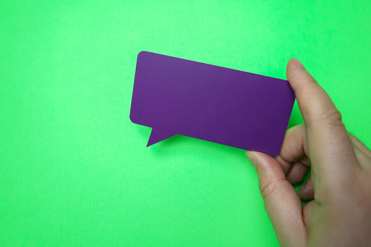 Man holding blank purple speech bubble on green background. - Powered by Adobe