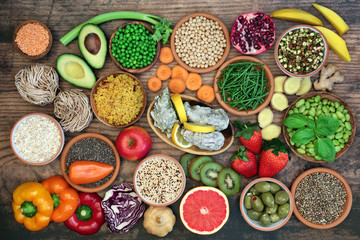 Health food for a healthy diet with foods and herbs high in antioxidants, anthocyanins, vitamins, minerals, protein, smart carbs, omega 3 and fibre. Flat lay on rustic wood.