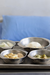 Thai Food Dishes on Tray have Steamed Rice, Green Curry with Chicken.  Stir Fried Cauliflower with Pork and Guava. Breakfast Meal for Patient.