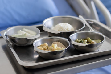 Thai Food Dishes on Tray have Steamed Rice, Green Curry with Chicken.  Stir Fried Cauliflower with Pork and Guava. Breakfast Meal for Patient.