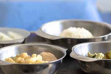 Thai Food Dishes on Tray have Steamed Rice, Green Curry with Chicken.  Stir Fried Cauliflower with Pork and Guava. Breakfast Meal for Patient.