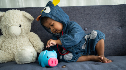 Cute  little asian  baby boy with piggy bank
