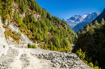 Mountain gravel road between Chame and Bhratang villages. Marshyangdi river valley, Annapurna circuit trek, Nepal.
