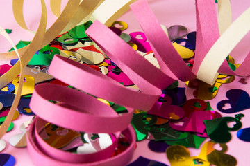 color confetti and streamers on pink background, party concept