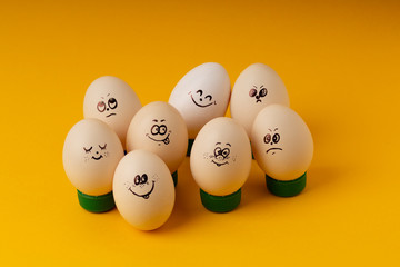Chicken Eggs With Smileys For Easter Painting on yellow background . Happy Easter concept
