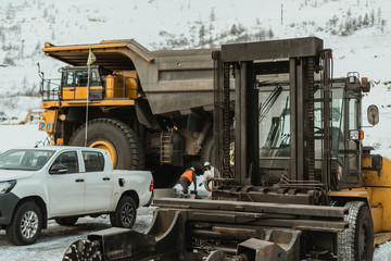 Repair of a mining dump truck at the gold mine site. © CjVitoS