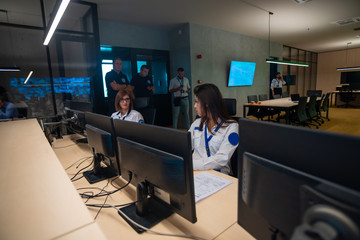 Female security guards working on computers while sitting in the main control room