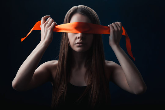 the girl blindfolded herself, with red tape, a game on a black background