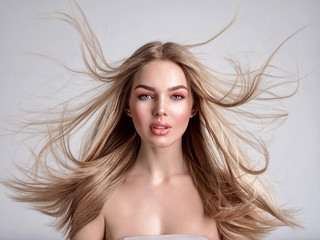 Portrait of a blonde beautiful woman with a long straight light hair. Flying hair.