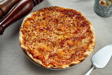 Homemade baked pizza margherita with tomatoes and mozzarella, red sauce on a on linen tablecloth. Close up view, flat lay