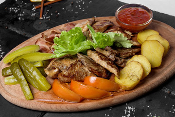 Grilled meat assortment with vegetables and potatoes