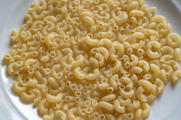 Golden pasta on a white plate close-up