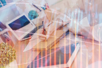 Financial graph displayed on woman's hand taking notes background. Concept of research. Double exposure