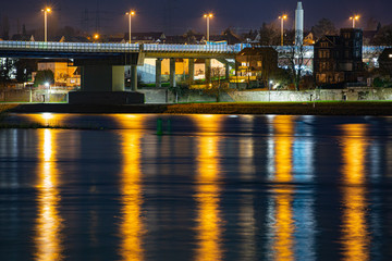 Fototapeta na wymiar Golden shimmering reflections of street lights in the water of the river rhine