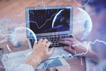 Multi exposure of forex graph with man working on computer on background. Concept of market...