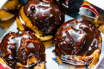 Take Away French Dessert Cream Filled  Chocolate Eclair in Plastic Box Package. Close Up Macro View.