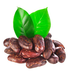 Heap of roasted cacao beans with green leaves isolated on a white background.