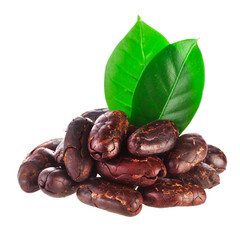 Heap of roasted cacao beans with green leaves isolated on a white background.
