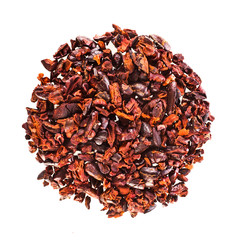 Heap of cacao nibs isolated on white background. Top view.