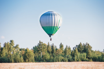 Fototapeta premium Balloon in the sky flies over trees