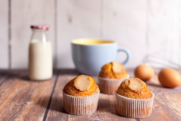 three delicious cupcakes and milk bottle