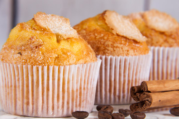 three delicious cupcakes close-up, coffee and cinnamon