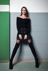 Fashion shot: portrait of beautiful girl dressed in black  skirt, blouse, gaiters and boots. Pretty...