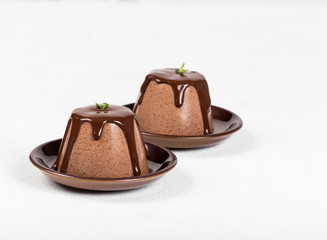 Italian dessert Panna cotta with chocolate sauce on a light background