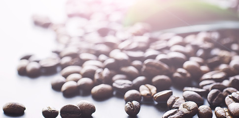 Coffee beans with green leaves for cooking. Bag of coffee. Coffee beans roasted on the table.