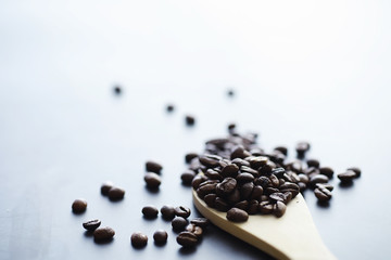 Bag of coffee. Coffee beans roasted on the table. Coffee beans with green leaves for cooking.