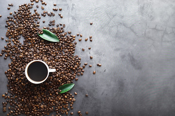 Bag of coffee. Coffee beans roasted on the table. Coffee beans with green leaves for cooking.