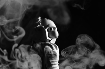 White scary mask on a black background with whites hand.